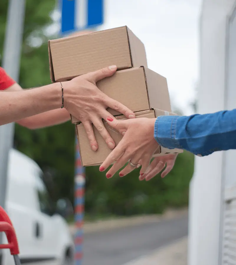 Estafeta a entregar uma encomenda a um cliente à porta